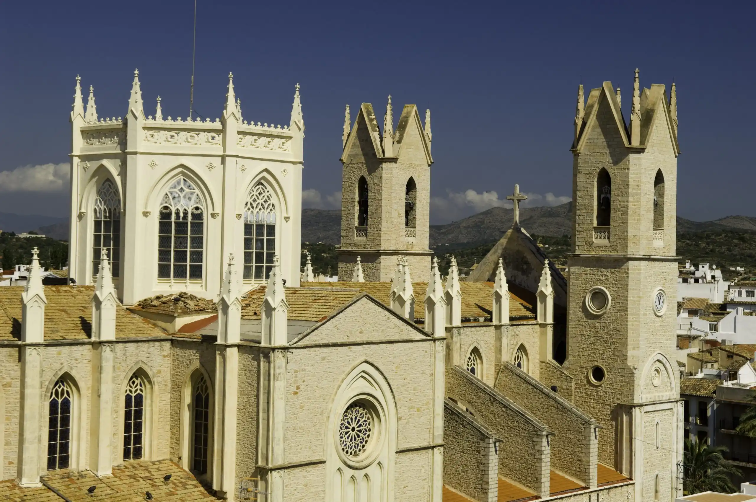 La iglesia de la Puríssima Xiqueta de Benissa, de piedra y estilo neogótico, alzándose sobre los tejados del casco antiguo