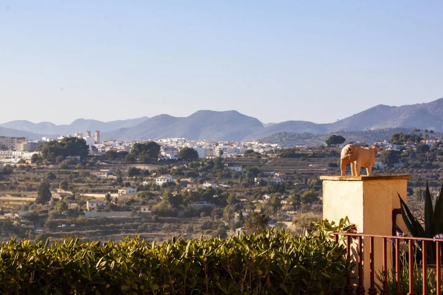 Vista del pueblo de Benissa desde la villa, con la torre de la iglesia destacando sobre los bancales y la sierra al fondo